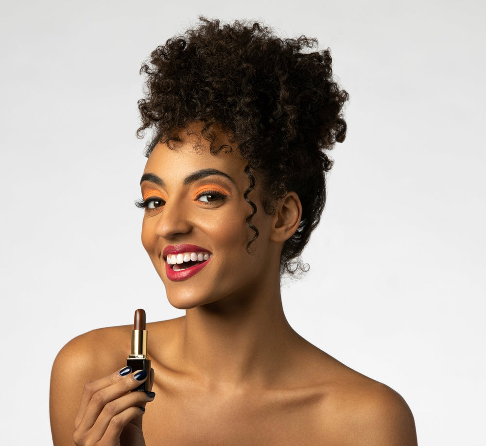 Woman applying brown color-changing lipstick with satin lipstain-like finish